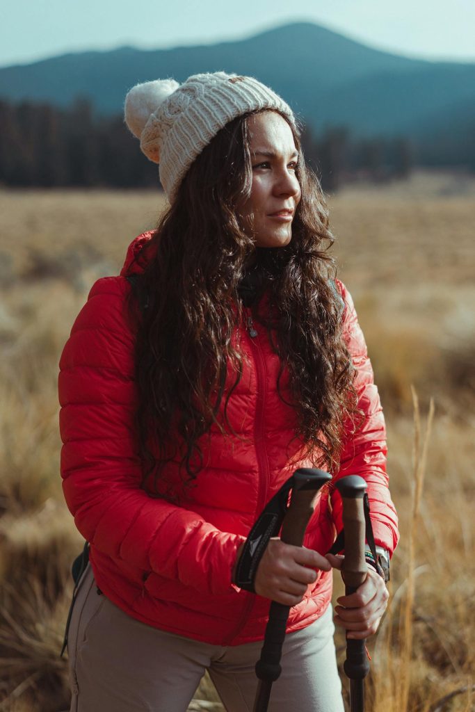 Девушка стоит на вершине горы, любуясь пейзажем.