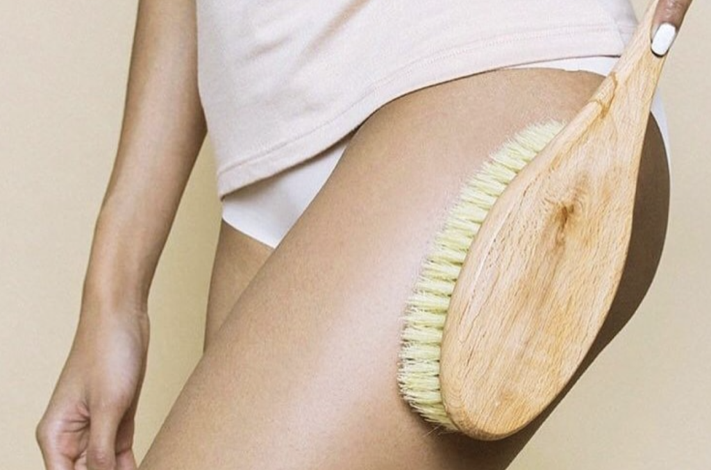 Девушка наносит крем на ноги после душа