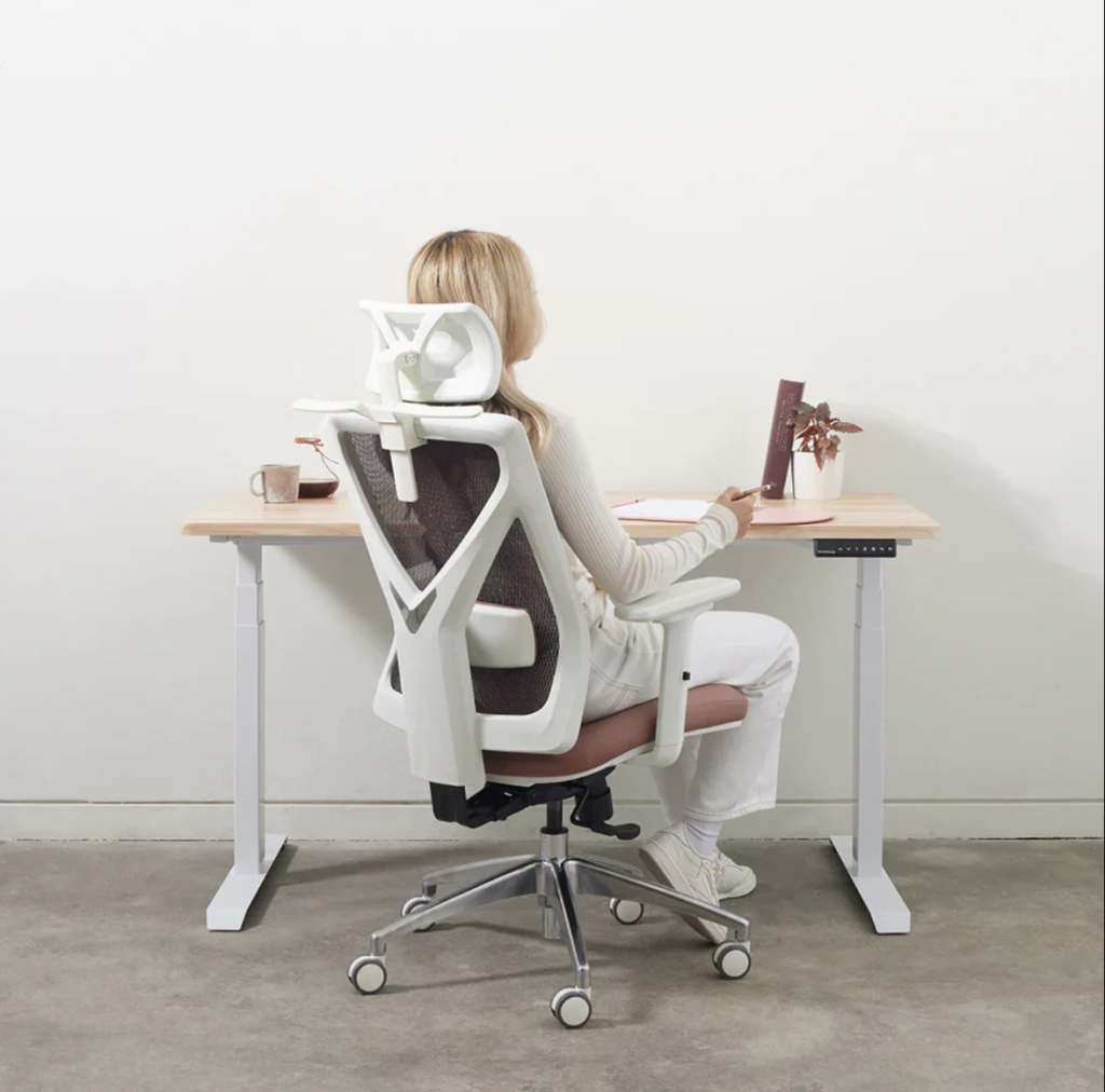 O femeie lucrează la biroul ei într-un spațiu luminos și confortabil acasă.